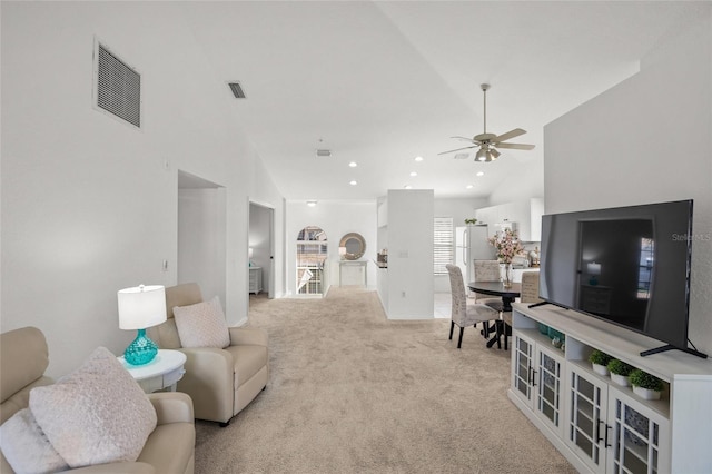 living room with high vaulted ceiling, light colored carpet, and ceiling fan