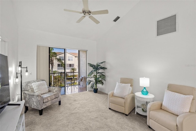 sitting room with ceiling fan, light colored carpet, and high vaulted ceiling