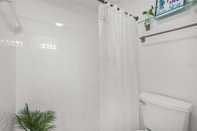 bathroom featuring a shower with curtain and toilet