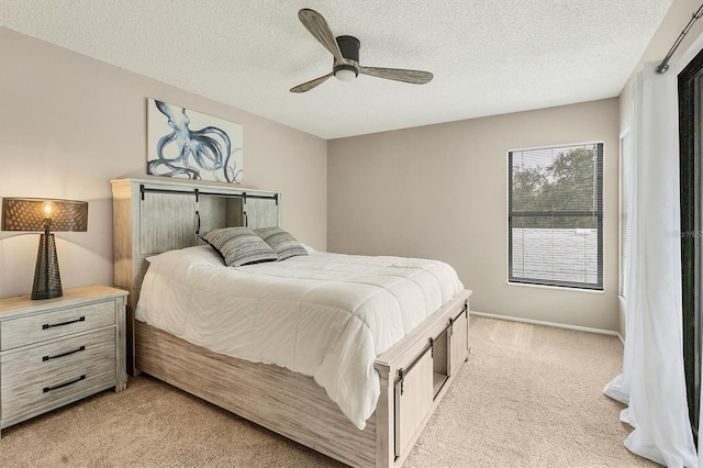 carpeted bedroom featuring a textured ceiling and ceiling fan