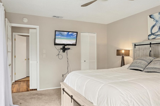 carpeted bedroom featuring ceiling fan, a textured ceiling, and a closet