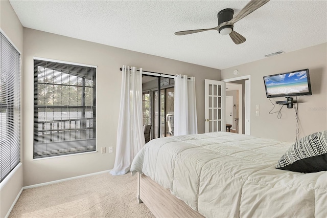 bedroom featuring multiple windows, carpet flooring, access to outside, and a textured ceiling