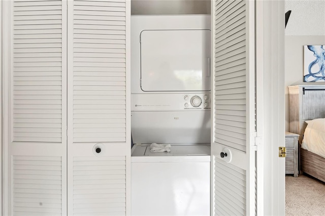 laundry area with stacked washer and dryer, a textured ceiling, and carpet