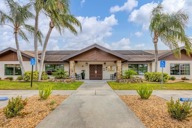 ranch-style home featuring french doors and a front yard