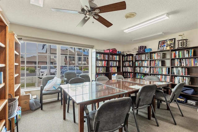 office area with ceiling fan, carpet flooring, and a textured ceiling