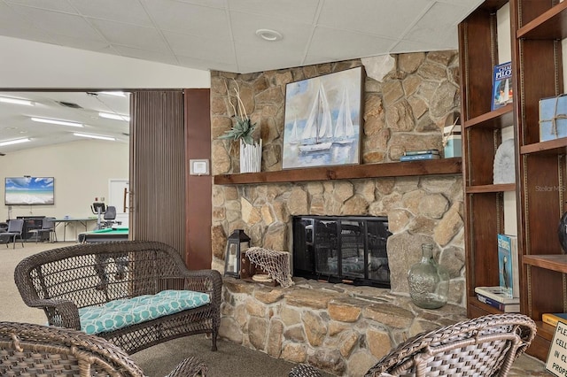 living room with a stone fireplace, vaulted ceiling, and carpet flooring