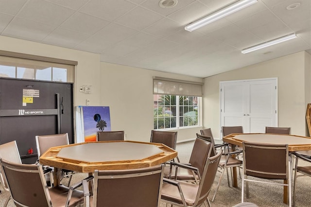 carpeted dining room featuring vaulted ceiling