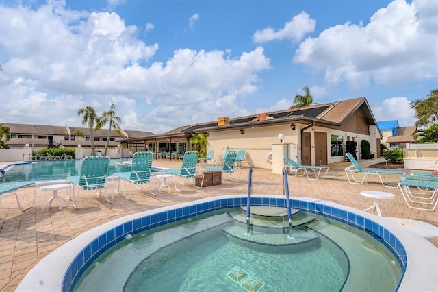 view of pool with a community hot tub and a patio area