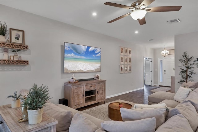 living room featuring dark wood-type flooring and ceiling fan with notable chandelier