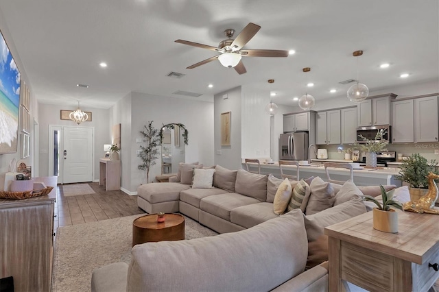 living room featuring light hardwood / wood-style flooring and ceiling fan