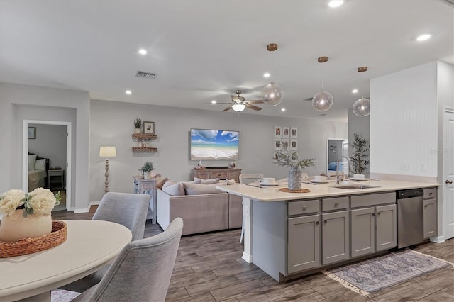 kitchen with gray cabinets, pendant lighting, sink, stainless steel dishwasher, and ceiling fan