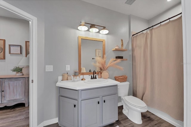 bathroom featuring vanity, toilet, and hardwood / wood-style floors