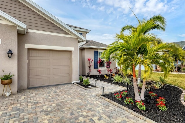 6428 Devesta Loop, Palmetto, FL 34221 - property entrance featuring stucco siding, decorative driveway, and an attached garage