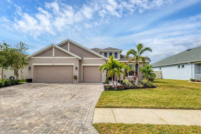 6428 Devesta Loop, Palmetto, FL 34221 - view of front of property featuring a garage, stucco siding, decorative driveway, and a front lawn