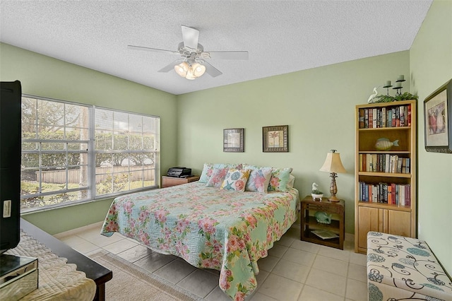 bedroom with ceiling fan, a textured ceiling, and light tile patterned flooring