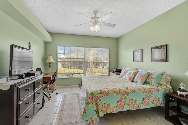 tiled bedroom with ceiling fan and a textured ceiling