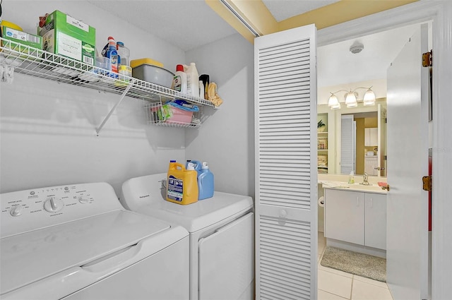 clothes washing area featuring sink, independent washer and dryer, and light tile patterned flooring