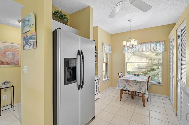 kitchen featuring pendant lighting, white cabinets, light tile patterned floors, stainless steel refrigerator with ice dispenser, and a textured ceiling