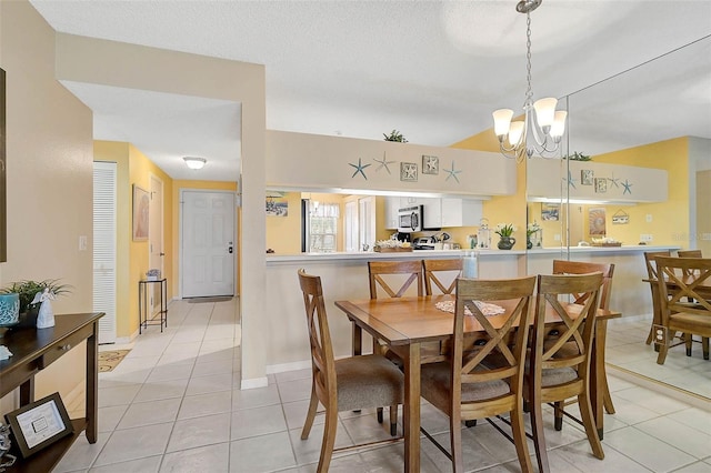 tiled dining space featuring a textured ceiling and a notable chandelier