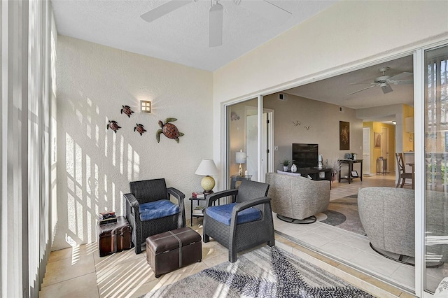 interior space featuring ceiling fan, a textured ceiling, and light tile patterned floors