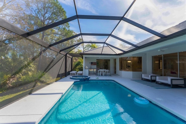 view of pool with ceiling fan, a patio, glass enclosure, and an in ground hot tub