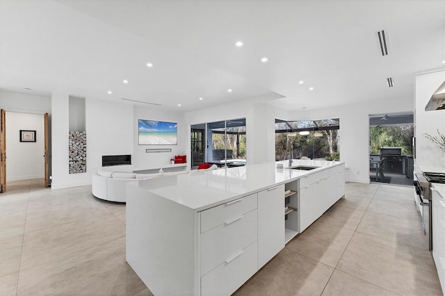 kitchen featuring stainless steel range, modern cabinets, white cabinetry, and recessed lighting