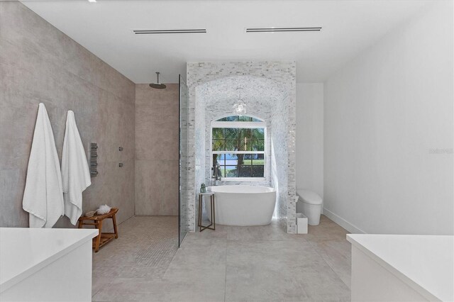 full bathroom featuring a soaking tub, walk in shower, and tile walls