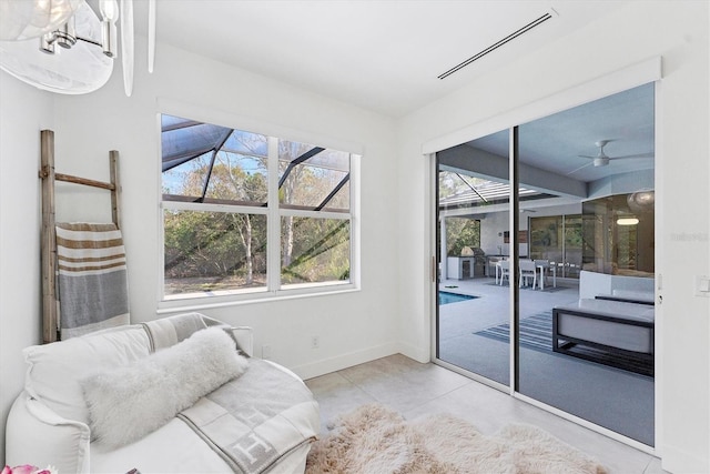 living area featuring a sunroom, baseboards, visible vents, and a wealth of natural light