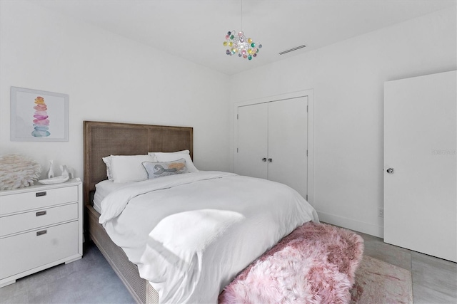 bedroom featuring visible vents, concrete flooring, and a closet