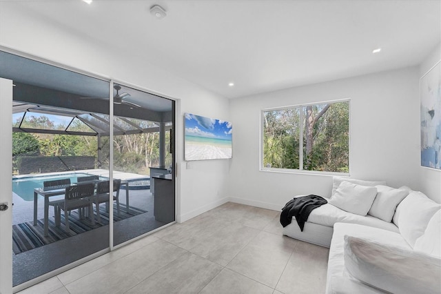 living room with recessed lighting, tile patterned flooring, a sunroom, and baseboards