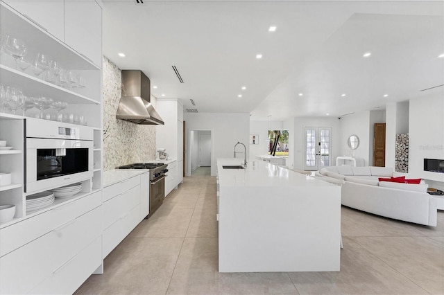 kitchen featuring white oven, white cabinets, wall chimney range hood, modern cabinets, and high end range