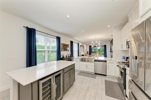 kitchen featuring white cabinetry, stainless steel appliances, kitchen peninsula, and a center island