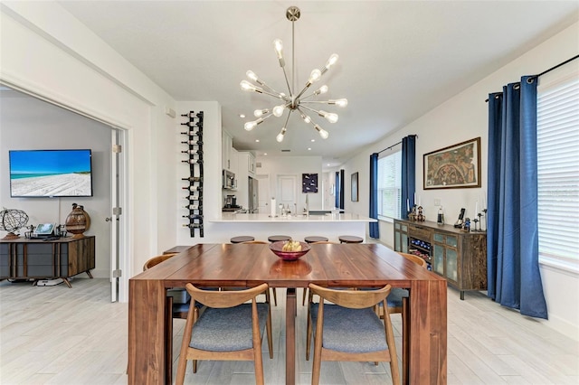 dining room with light wood-type flooring and an inviting chandelier