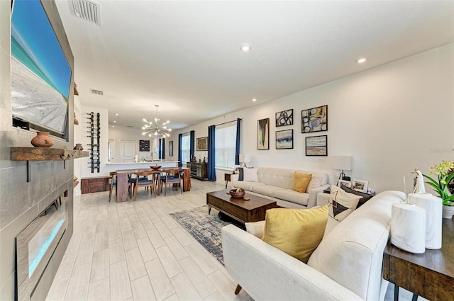 living room with a chandelier and light hardwood / wood-style floors