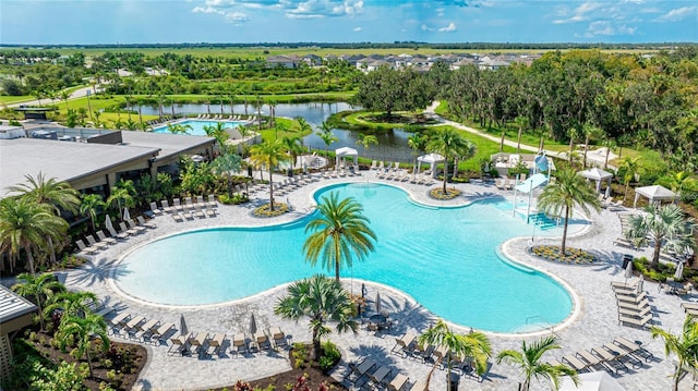 view of pool with a water view and a patio