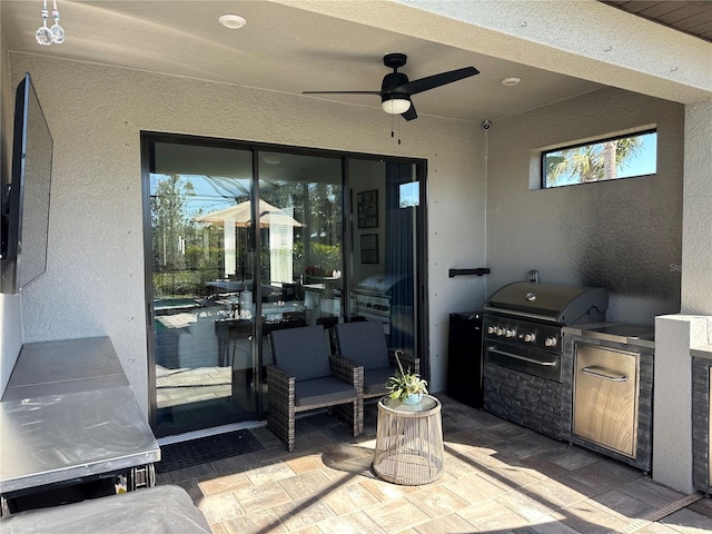 view of patio / terrace with a grill, ceiling fan, and an outdoor kitchen