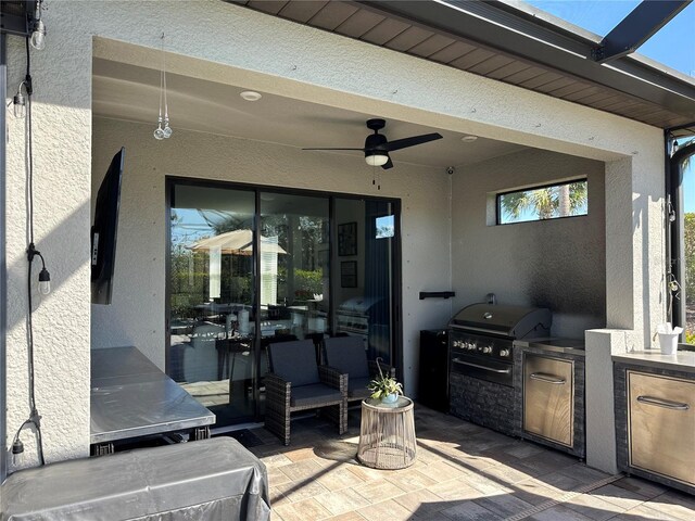 view of patio with area for grilling, a grill, and ceiling fan