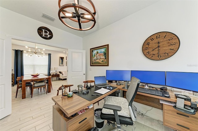 home office with an inviting chandelier and light hardwood / wood-style flooring