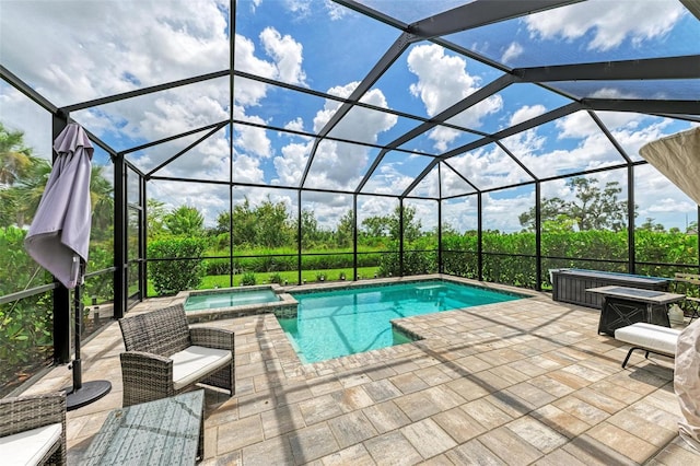 view of pool featuring an in ground hot tub, a patio, and glass enclosure