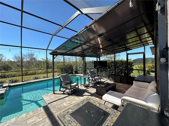 view of pool featuring an outdoor living space with a fire pit, glass enclosure, and a patio area