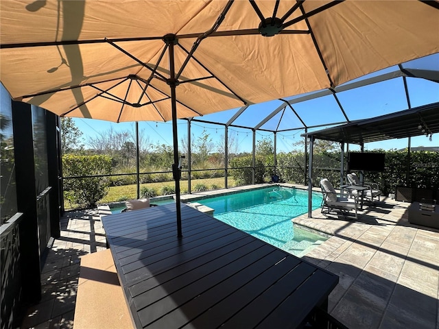 view of pool with a patio area and glass enclosure