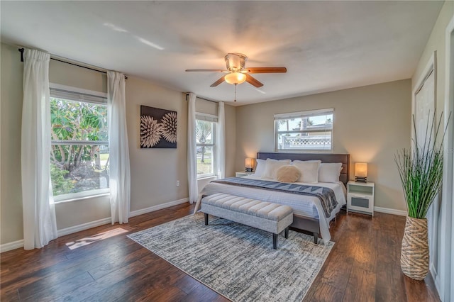 bedroom with ceiling fan, dark hardwood / wood-style floors, and multiple windows