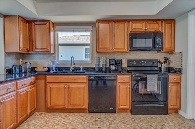 kitchen with dark stone countertops, a raised ceiling, sink, and black appliances