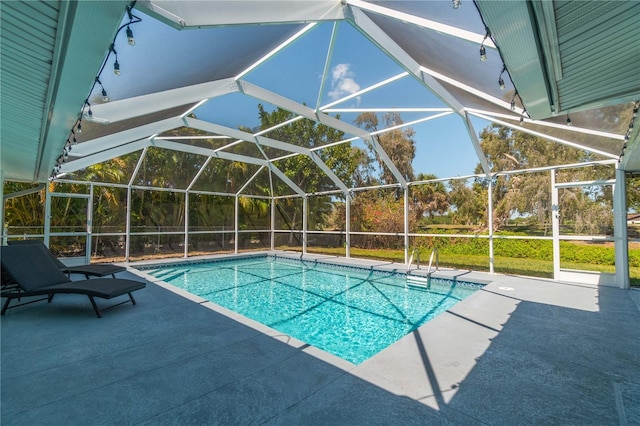 view of swimming pool featuring a patio area and glass enclosure