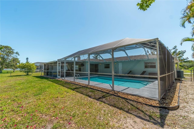 view of swimming pool with a yard, a patio area, and glass enclosure