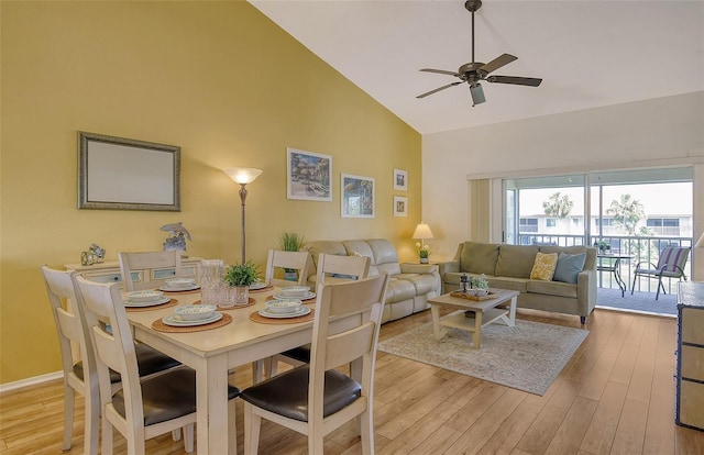 dining space with ceiling fan, high vaulted ceiling, and light hardwood / wood-style flooring