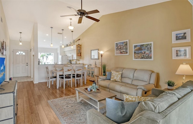 living room featuring ceiling fan, high vaulted ceiling, and light hardwood / wood-style floors