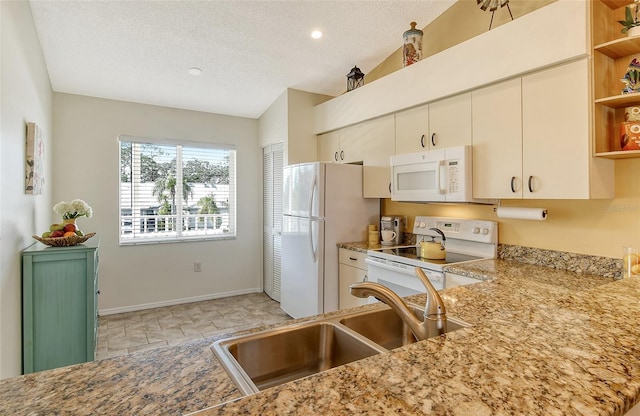 kitchen featuring sink, vaulted ceiling, a textured ceiling, kitchen peninsula, and white appliances