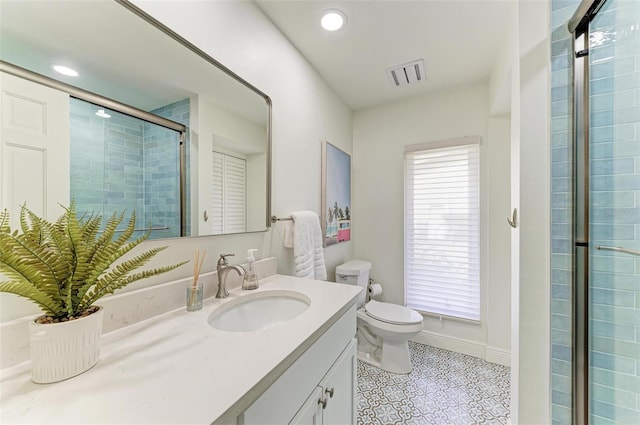 bathroom with a shower with door, vanity, a healthy amount of sunlight, and toilet