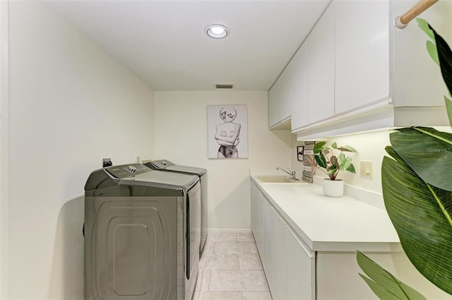 laundry room with cabinets, washer and dryer, and sink